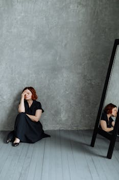 A Stressed Woman Leaning on a Concrete Wall while Sitting on the Floor