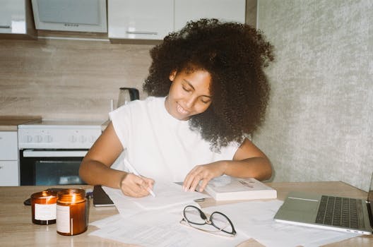 A Woman with Curly Hair While Writing on the Paper