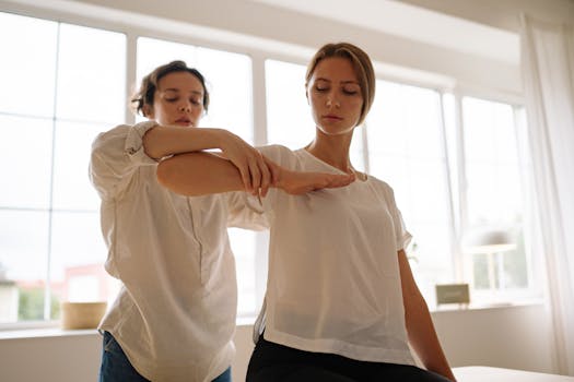 Woman in White Long Sleeve Shirt Holding Woman's Arm